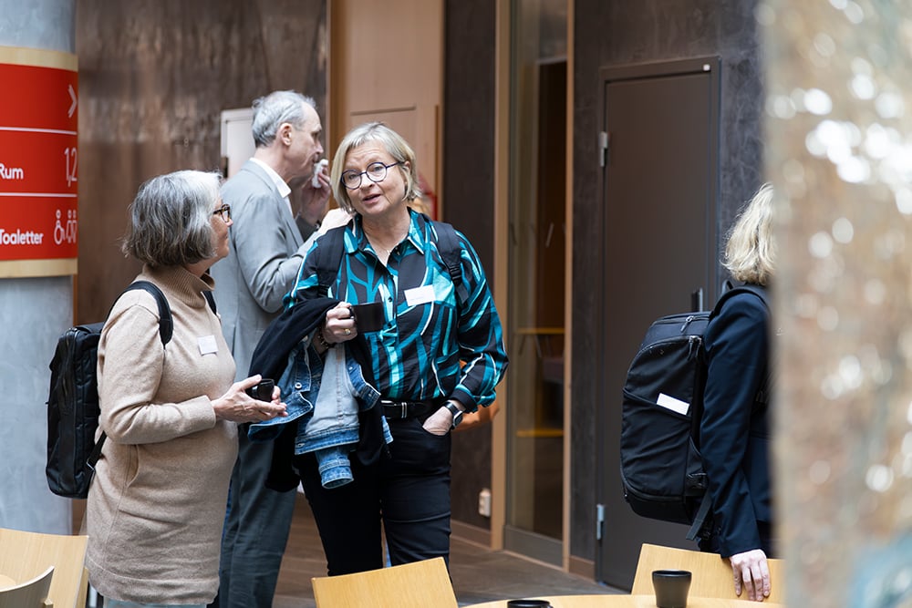 Två kvinnor som står upp och samtalar på mingel